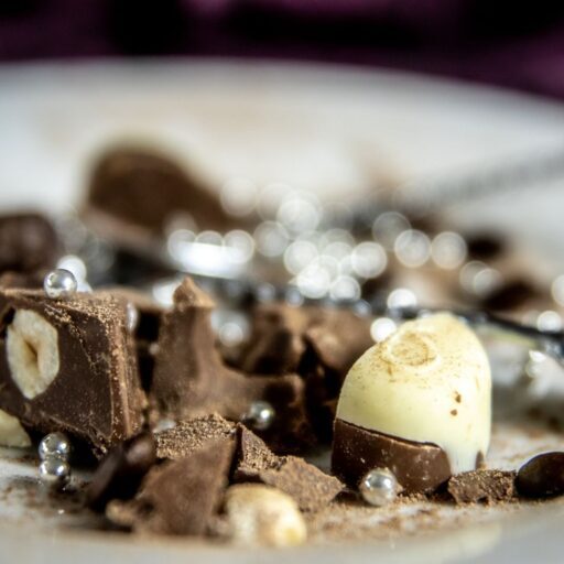 Artistic close-up of gourmet chocolate pieces and decorations on a plate.