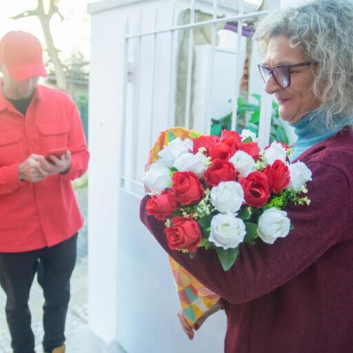 A Woman Receiving a Bouquet of Flowers from the Deliveryman