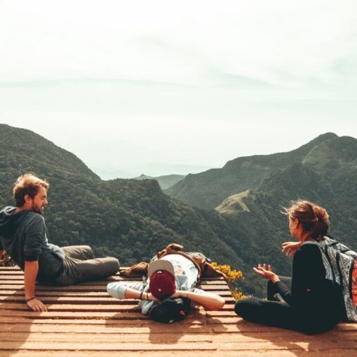 three people overlooking mountains