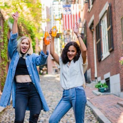 2 women standing on brown brick floor during daytime